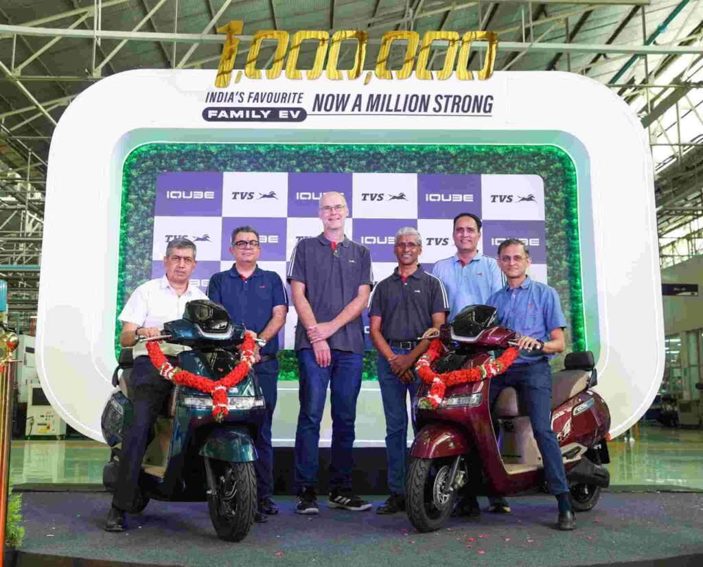 TVS iQube Electric Scooter के 10 लाख यूनिट्स उत्पादन का जश्न मनाते हुए कंपनी के अधिकारी और दो TVS iQube स्कूटर